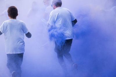 People running amidst powder paint in city