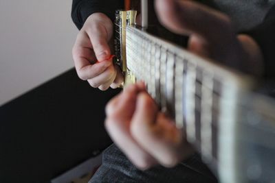 Midsection of man playing guitar