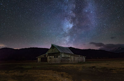 House on field against sky at night