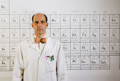 Portrait of man standing against wall