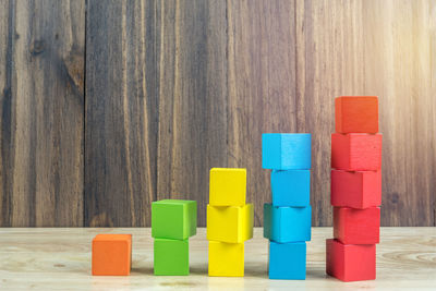 Stack of multi colored toy on wooden table