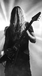 Man playing guitar against sky