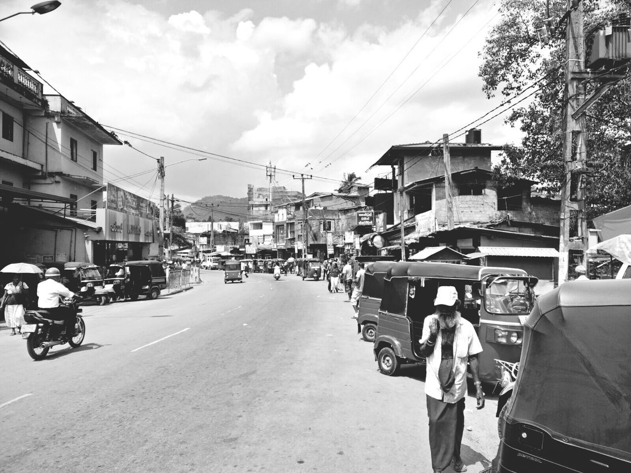 transportation, building exterior, architecture, mode of transport, land vehicle, city, street, sky, built structure, cloud - sky, city street, outdoors, car, day, real people, men, road, adults only, adult, people