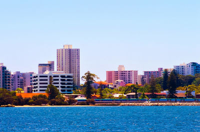 Buildings in city against clear sky