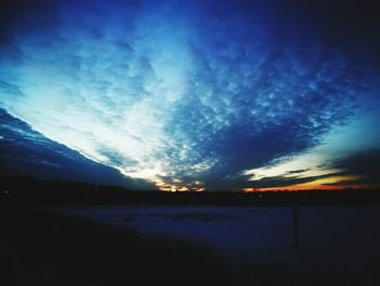 Silhouette landscape against blue sky during sunset