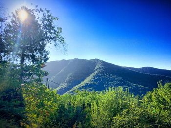 Scenic view of mountains against blue sky