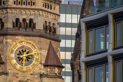 Low angle view of clock tower amidst buildings in city