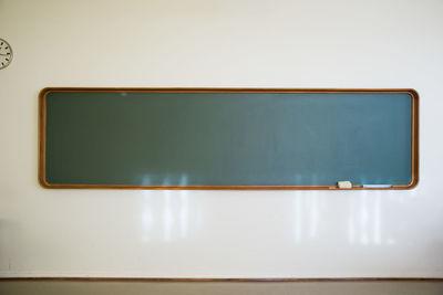 Vintage chalkboard in wooden frame on white wall