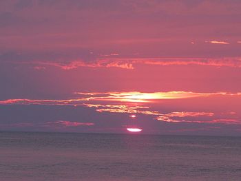 Scenic view of sea against romantic sky at sunset