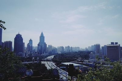 Buildings in city against cloudy sky