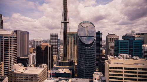 Buildings in city against cloudy sky