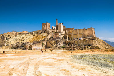 Old ruin building against clear blue sky