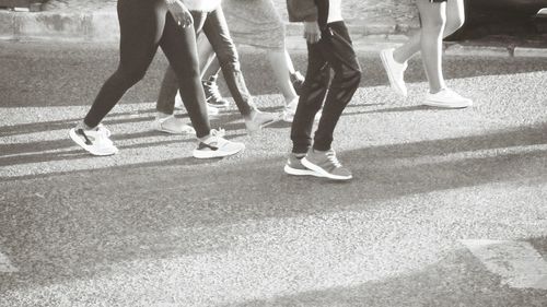 Low section of people walking on zebra crossing