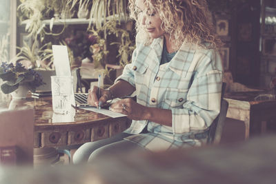 Portrait of young woman sitting on table