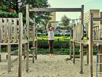 Portrait of smiling girl standing on rope in playground