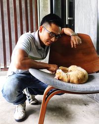Man with cat lying on seat at home