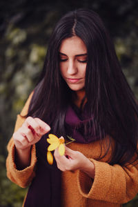 Portrait of young woman holding heart shape