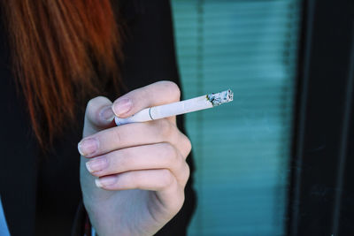 Midsection of woman smoking cigarette