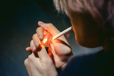 Close-up of young woman lighting cigarette