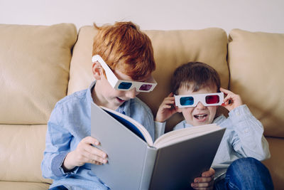 Boys sitting on sofa at home