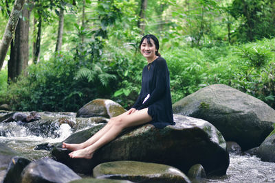 Portrait of woman sitting on rock