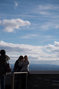 Rear view of men standing against mountain range