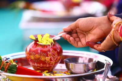 Close-up of hand holding spoon in indian rituals wedding