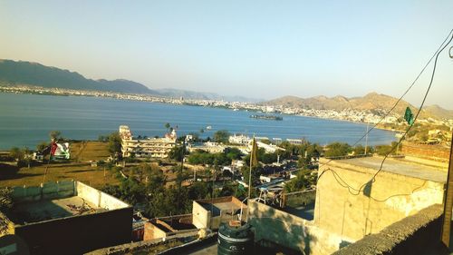 High angle view of city by sea against clear sky