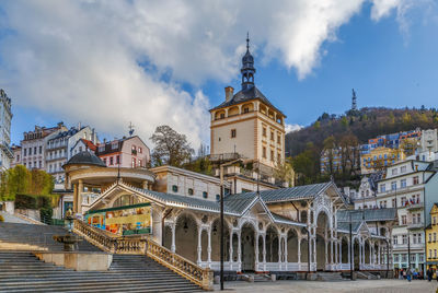 Buildings in city against cloudy sky