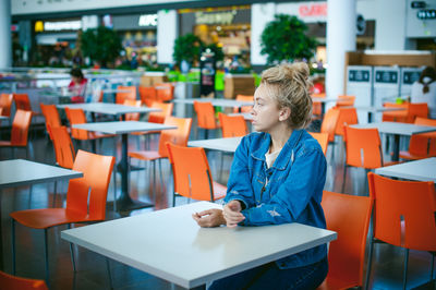 Woman sitting on chair at supermarket