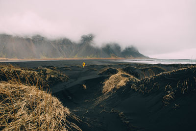 Man on black sand in desert