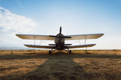 Low angle view of airplane on field against sky