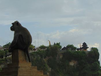 Monkey statue against trees and sky