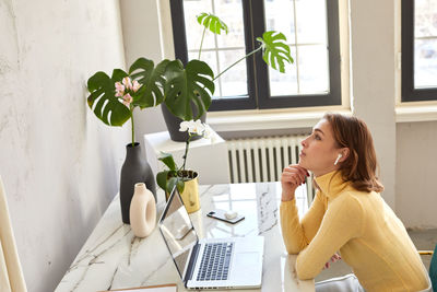 Side view of businesswoman thinking while sitting at office