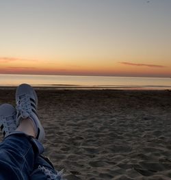 Low section of man relaxing on beach