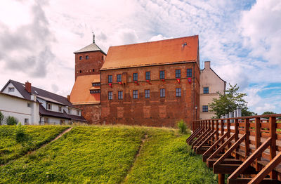 View of the gothic castle of pomeranian dukes in darlowo. a moat and a bridge in the foreground. 