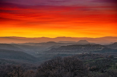 Scenic view of mountains against orange sky