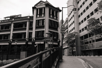 Railroad tracks amidst buildings in city against sky