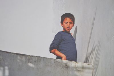 Low angle view of boy standing at building terrace