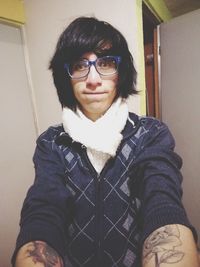 Portrait of smiling woman standing at home