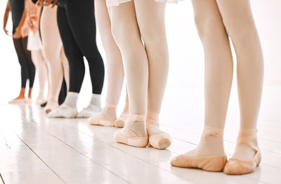 Low section of people standing on hardwood floor