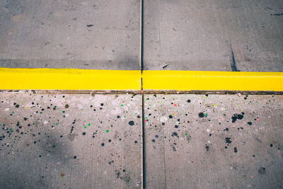 High angle view of yellow lines on tiled floor