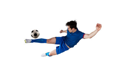 Man playing soccer ball against white background