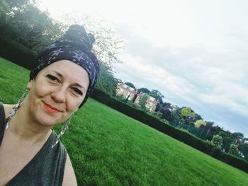 Portrait of smiling young woman against sky