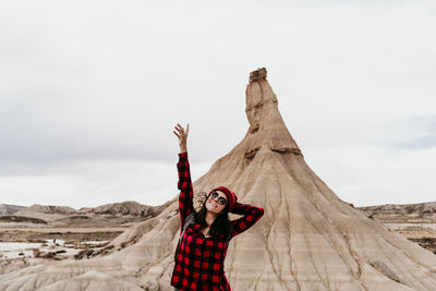 Full length of woman standing on desert against sky