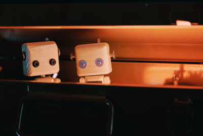 Small wooden robots locked in a metal box. hide from problems and the outside world