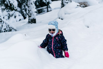 Rear view of woman skiing on snow covered field