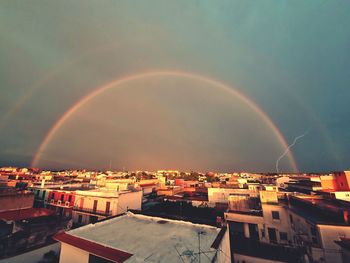 Aerial view of rainbow over buildings in city