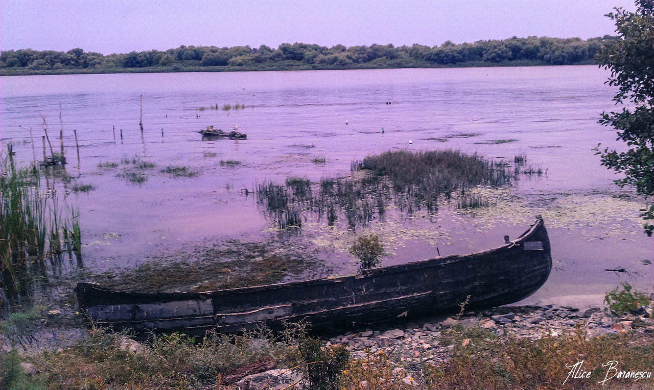 ABANDONED BOATS MOORED ON BEACH AGAINST CLEAR SKY