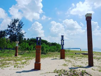 Wooden posts on field against sky